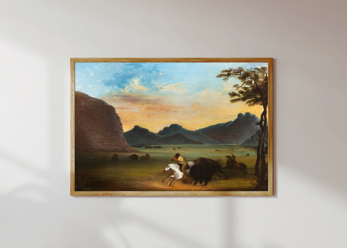 Framed art print of Buffalo Hunt by Alfred Jacob Miller, in a light wood frame on a sunlit white wall