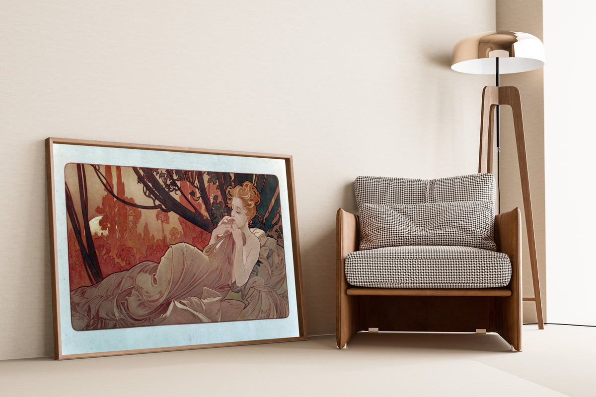 Framed art print of Dusk by Alphonse Mucha, leaning against a wall beside an armchair and a floor lamp