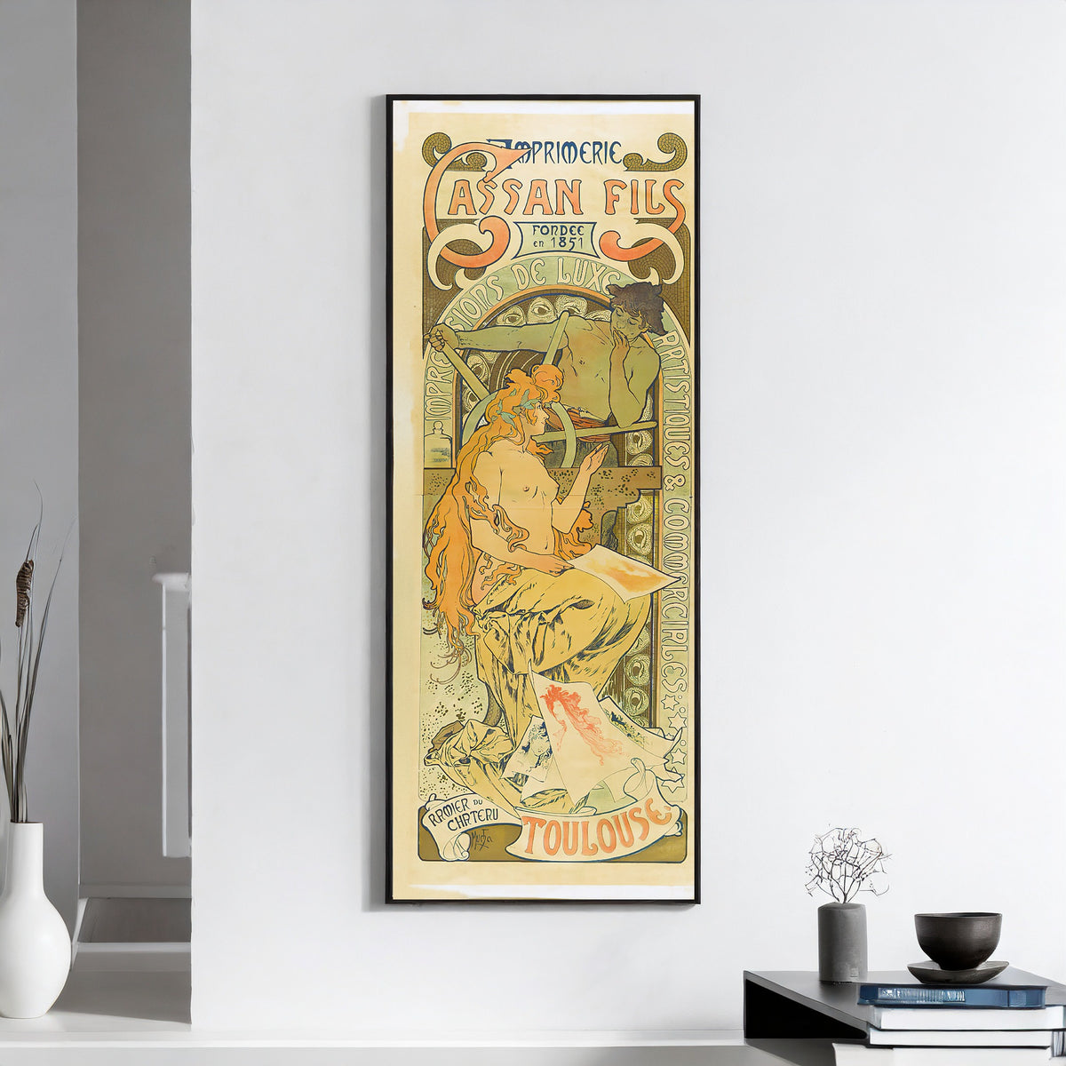 Imprimerie Cassan Fils, Toulouse by Alphonse Mucha — framed on a white wall above books and a bowl