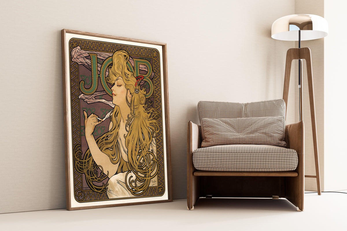 Framed art print of Job by Alphonse Mucha, leaning against a wall beside an armchair and a floor lamp
