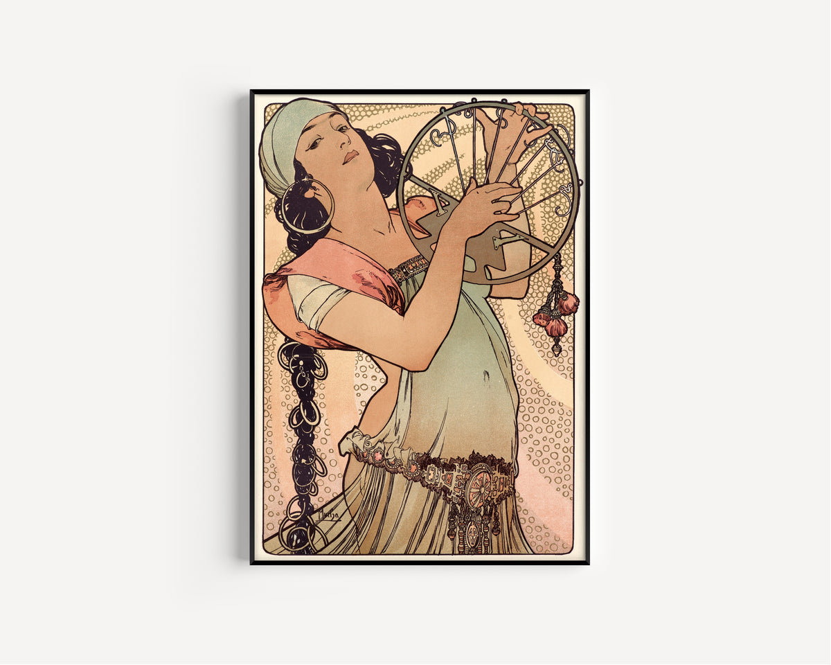 Framed art print of Salomé by Alphonse Mucha, in a slim black frame on a plain white wall