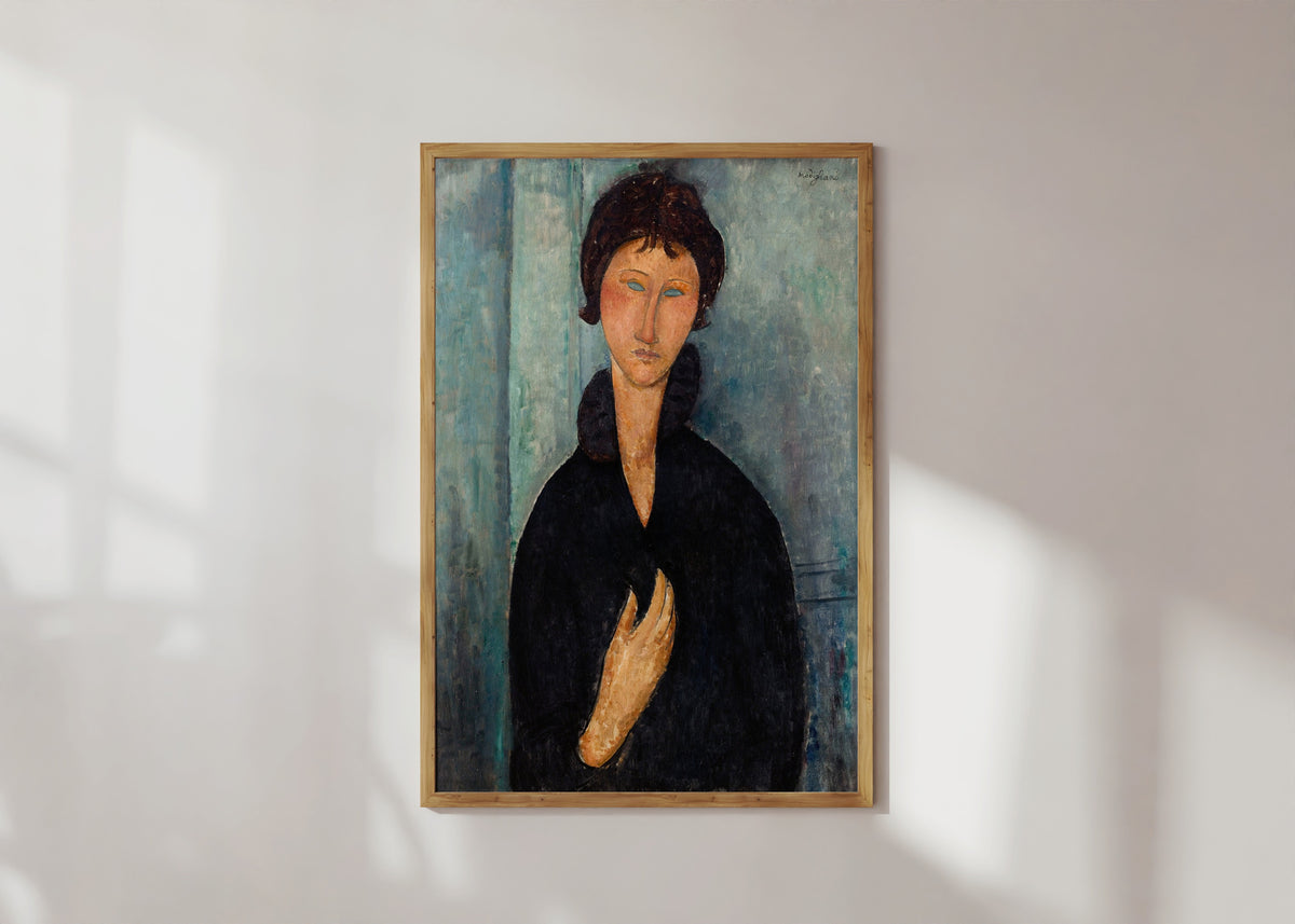 Framed art print of Woman with Blue Eyes by Amedeo Modigliani, in a light wood frame on a sunlit white wall