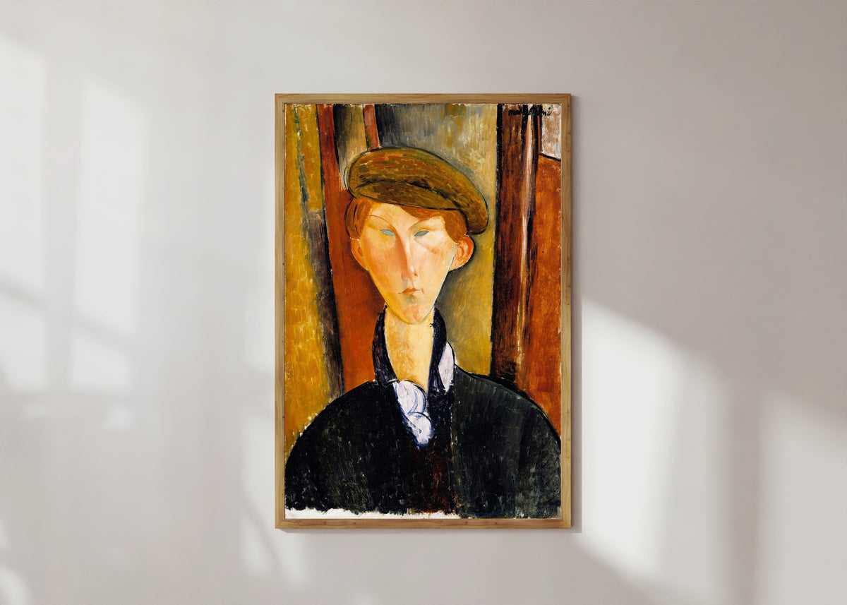 Framed art print of Young Man with a Cap by Amedeo Modigliani, in a light wood frame on a sunlit white wall