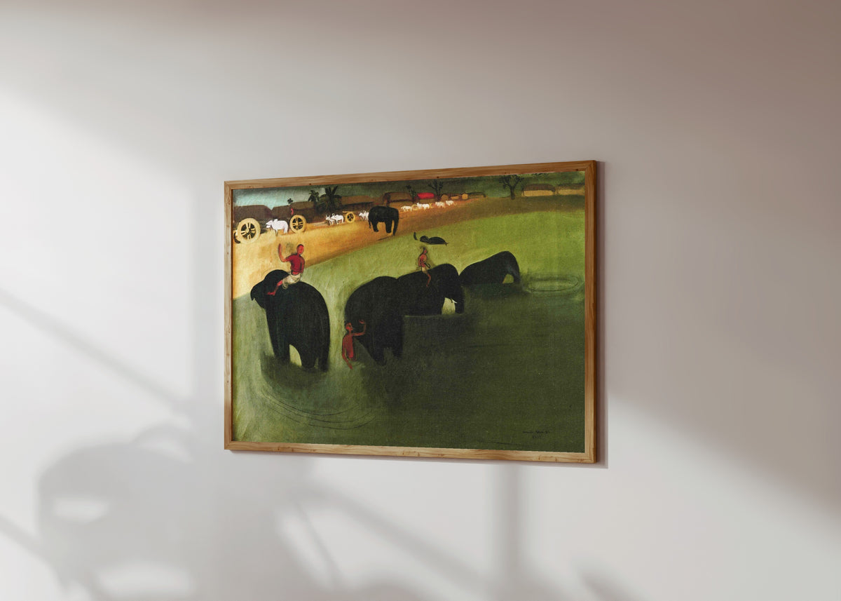 Framed art print of Elephants Bathing in a Green Pool (1938) by Amrita Sher-Gil, in a light wood frame on a sunlit white wall, seen at a slight angle