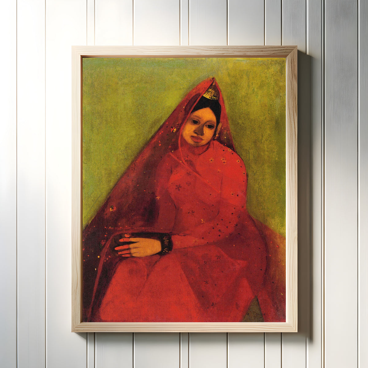 Framed art print of The Bride (1940) by Amrita Sher-Gil, in a light wood frame on a white panelled wall