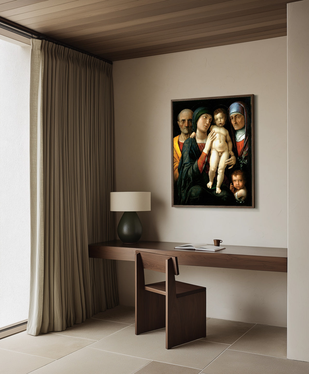 Framed art print of The Holy Family by Andrea Mantegna, in a dark wood frame on a plaster wall above a walnut desk