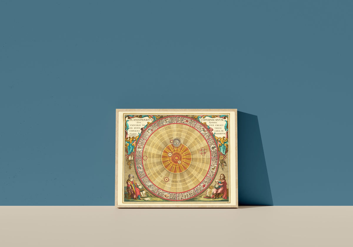 Framed art print of The Copernican Planisphere (Plate 4, Teal Colouring) by Andreas Cellarius, in a light wood frame leaning on a blue wall