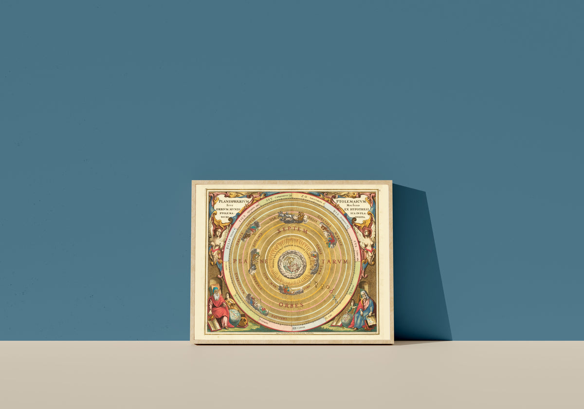 Framed art print of The Ptolemaic Planisphere (Plate 1) by Andreas Cellarius, in a light wood frame leaning on a blue wall