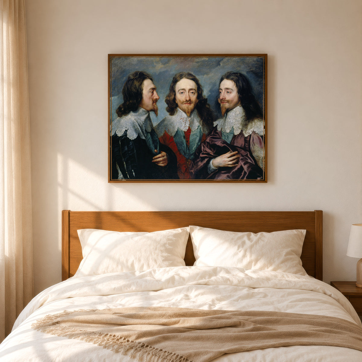 Framed art print of Charles I in Three Positions by Anthony van Dyck, in a slim wood frame above a bed in a sunlit bedroom