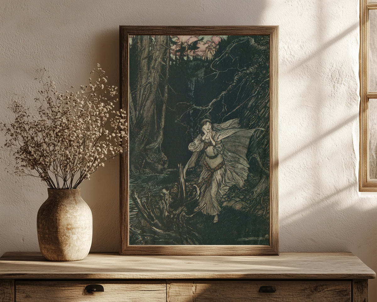 Framed art print of Bertalda in the Black Valley by Arthur Rackham, in a dark wood frame leaning on a rustic console beside dried flowers