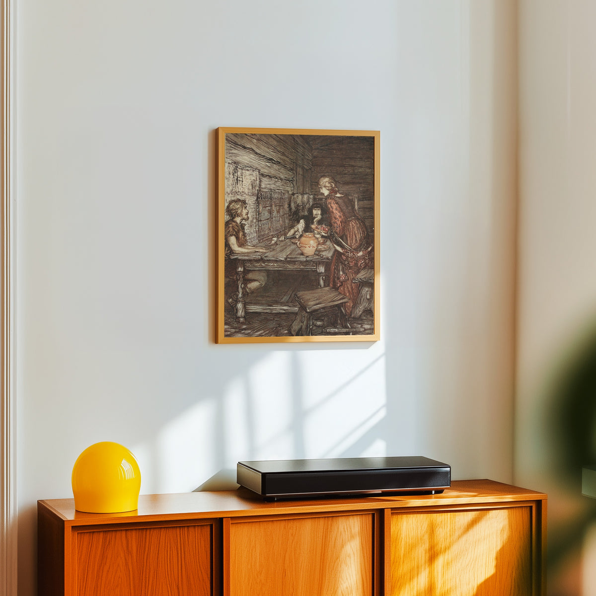 Framed art print of Hunding Discovers the Likeness Between Siegmund and… by Arthur Rackham, in a light wood frame on a white wall above an orange sideboard
