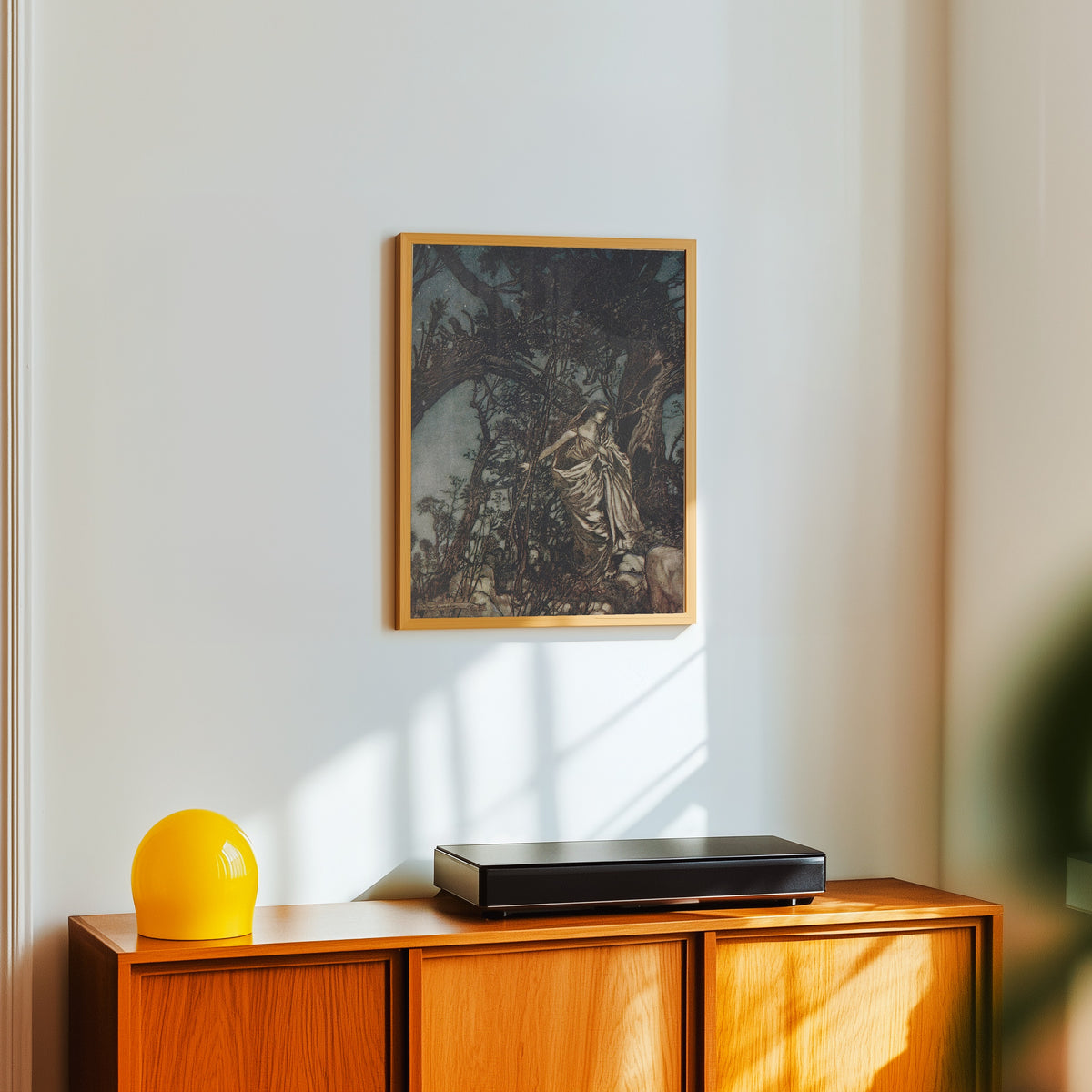 Framed art print of Never So Weary, Never So in Woe by Arthur Rackham, in a light wood frame on a white wall above an orange sideboard