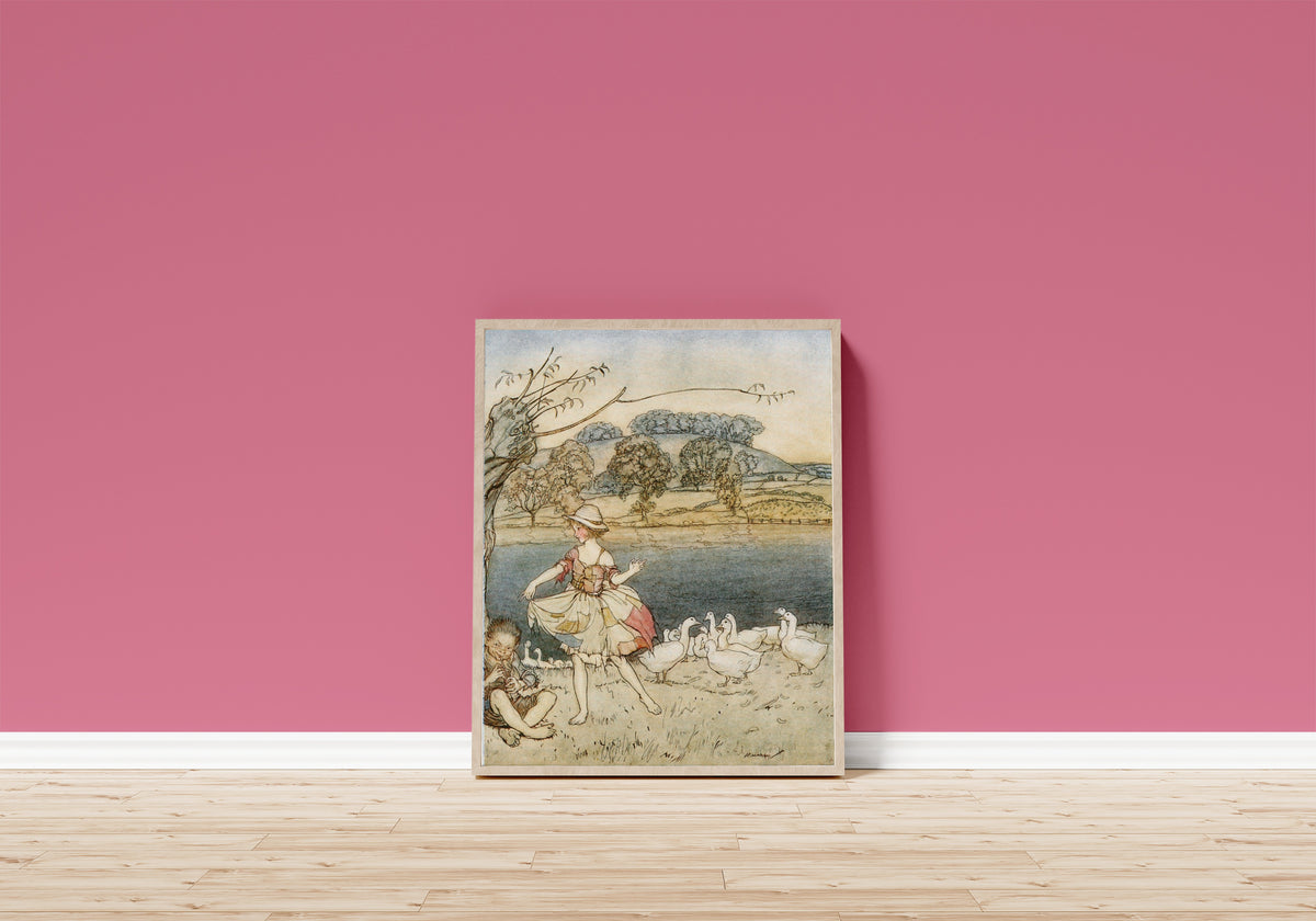 Framed art print of Tattercoats Dancing While the Gooseherd Pipes by Arthur Rackham, in a light wood frame leaning on a pink wall above a wooden floor