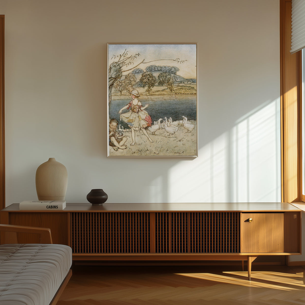 Framed art print of Tattercoats Dancing While the Gooseherd Pipes by Arthur Rackham, in a thin light frame on a sunlit wall above a wooden sideboard
