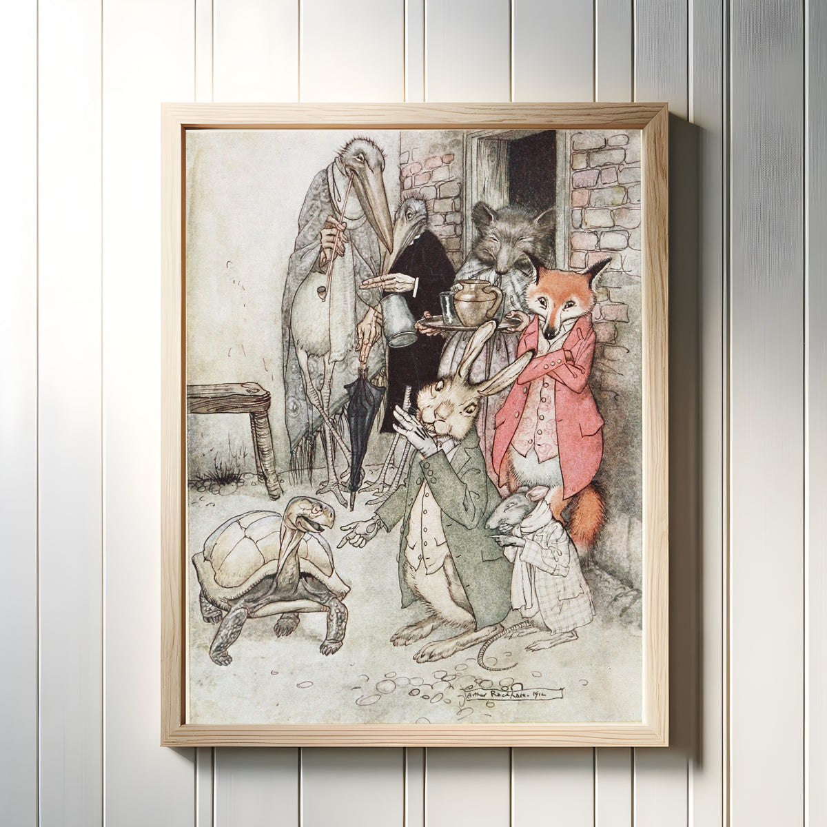 Framed art print of The Hare and the Tortoise by Arthur Rackham, in a light wood frame on a white panelled wall