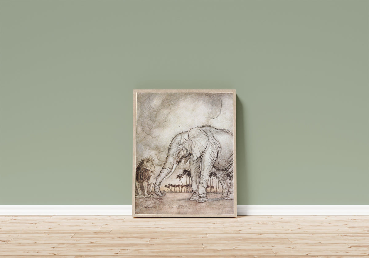 Framed art print of The Lion, Jupiter, and the Elephant by Arthur Rackham, in a light wood frame leaning on a sage green wall above a wooden floor