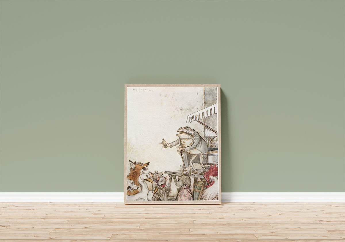 Framed art print of The Quack Frog by Arthur Rackham, in a light wood frame leaning on a sage green wall above a wooden floor