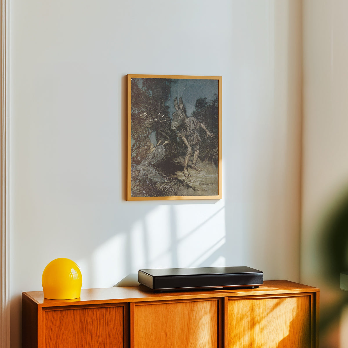 Framed art print of What Angel Wakes Me from My Flowery Bed? by Arthur Rackham, in a light wood frame on a white wall above an orange sideboard