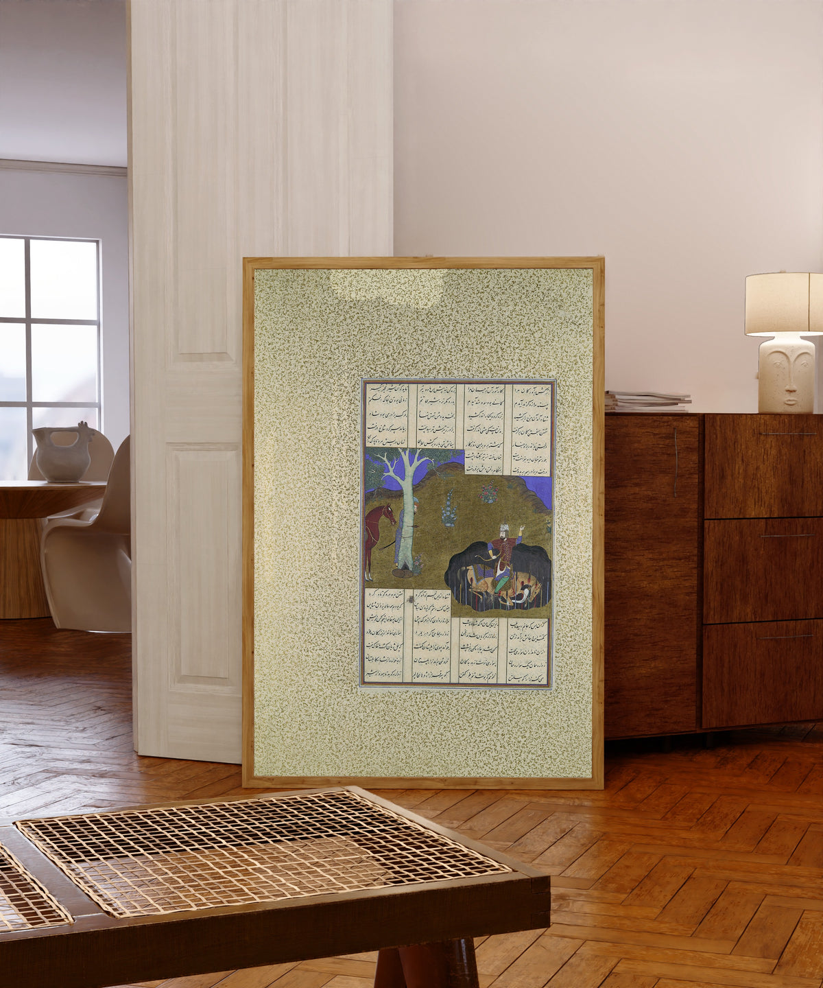 Framed art print of Shahnama of Shah Tahmasp: Rustam Avenges… by Bashdan Qara (attributed), in a light wood frame leaning in a warm room with a parquet floor
