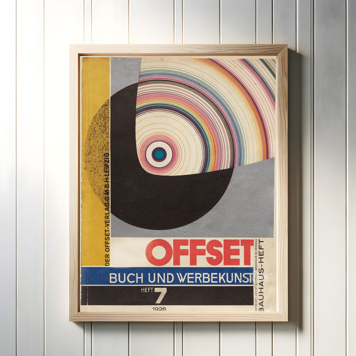 Framed art print of Bauhaus Offset Magazine Cover by Joost Schmidt, in a light wood frame on a white panelled wall