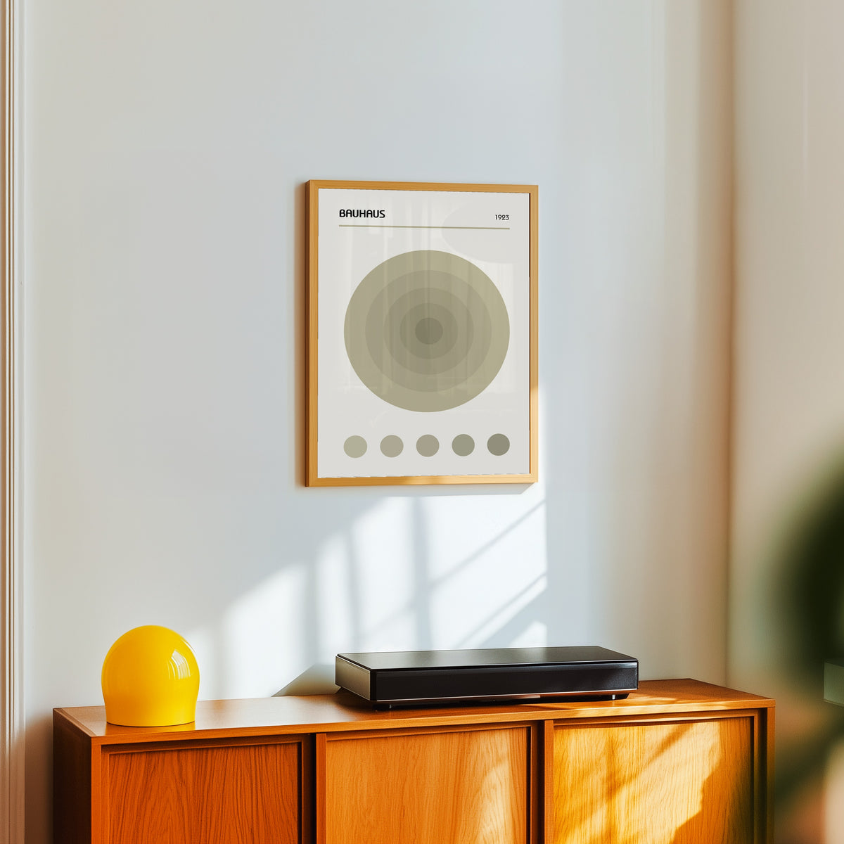 Framed art print of The Target by Bauhaus, in a light wood frame on a white wall above an orange sideboard