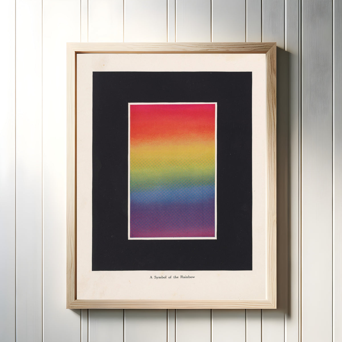 Framed art print of Symbol of the Rainbow by Bonnie E. Snow, in a light wood frame on a white panelled wall