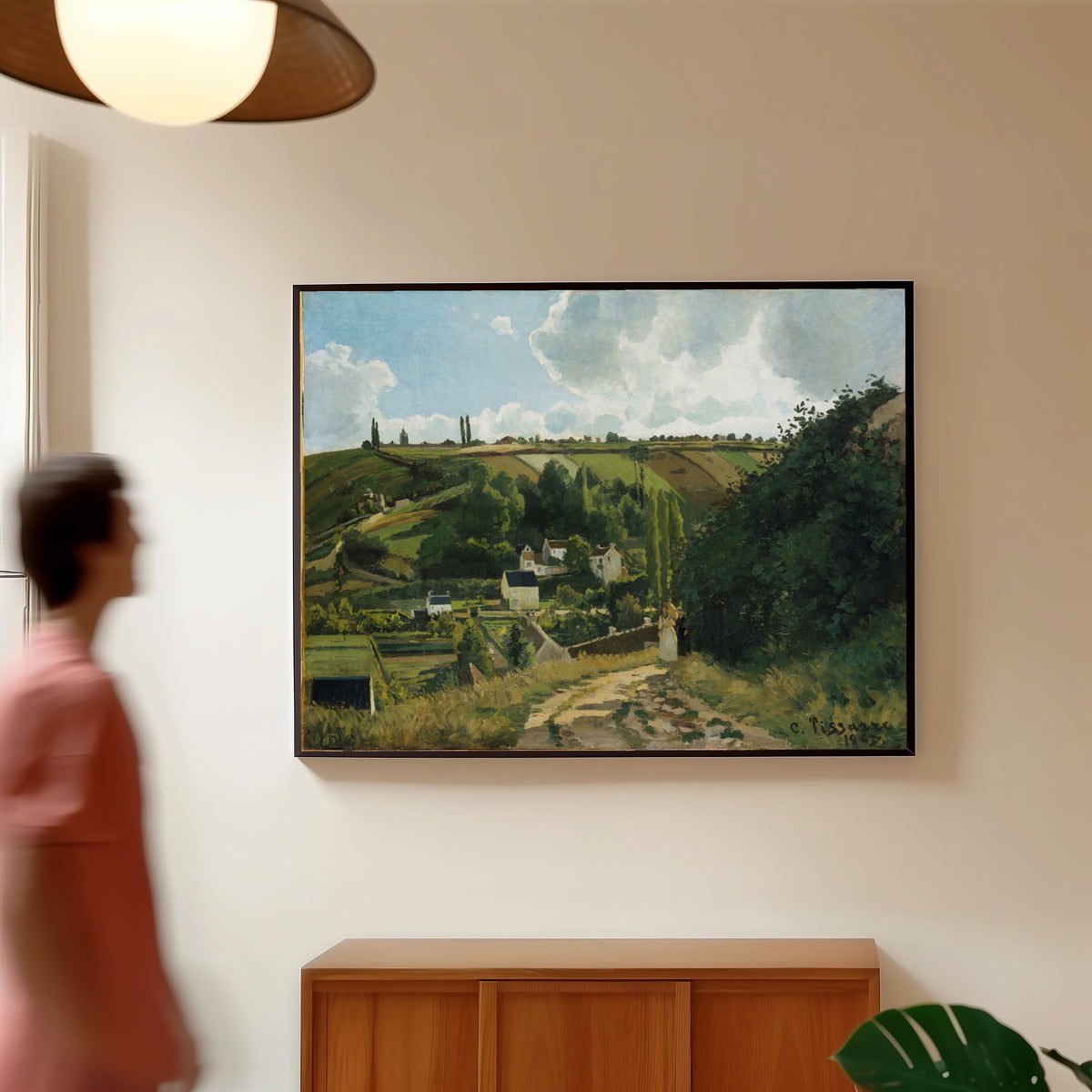 Framed art print of Jalais Hill, Pontoise by Camille Pissarro, in a slim black frame on a warm wall in a sunlit room