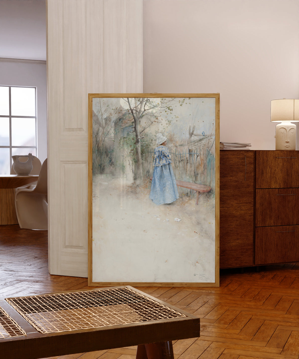 Framed art print of Autumn by Carl Larsson, in a light wood frame leaning in a warm room with a parquet floor