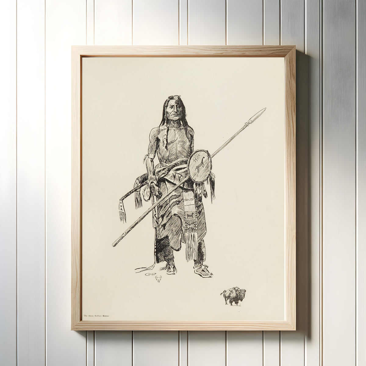 Framed art print of The Sioux Buffalo Hunter by Charles M. Russell, in a light wood frame on a white panelled wall