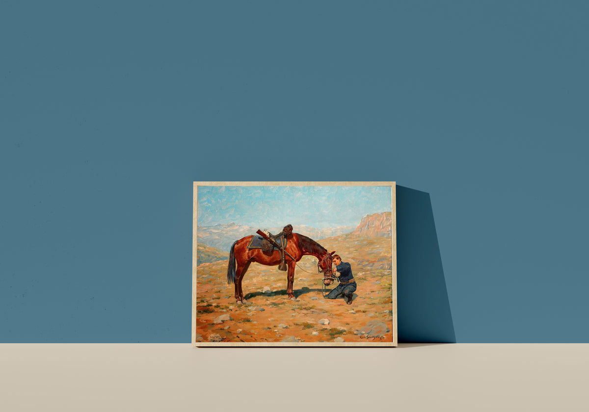 Framed art print of The Last Drop by Charles Schreyvogel, in a light wood frame leaning on a blue wall
