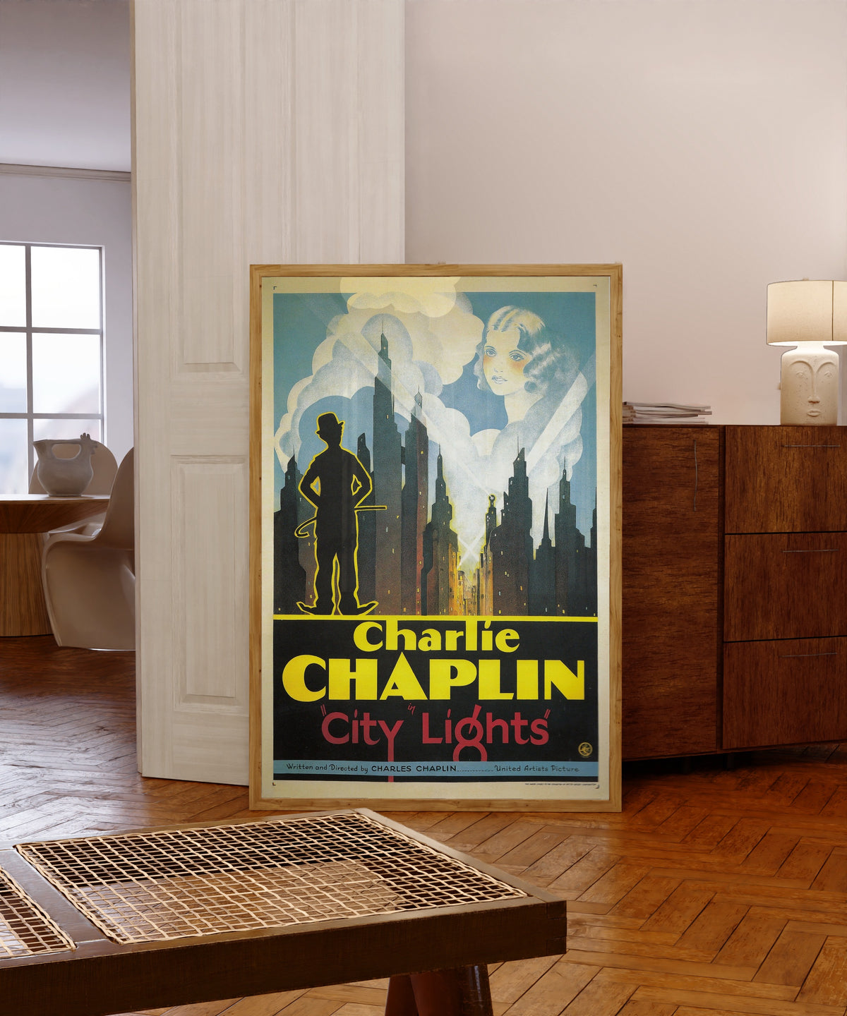 Framed art print of City Lights, in a light wood frame leaning in a warm room with a parquet floor