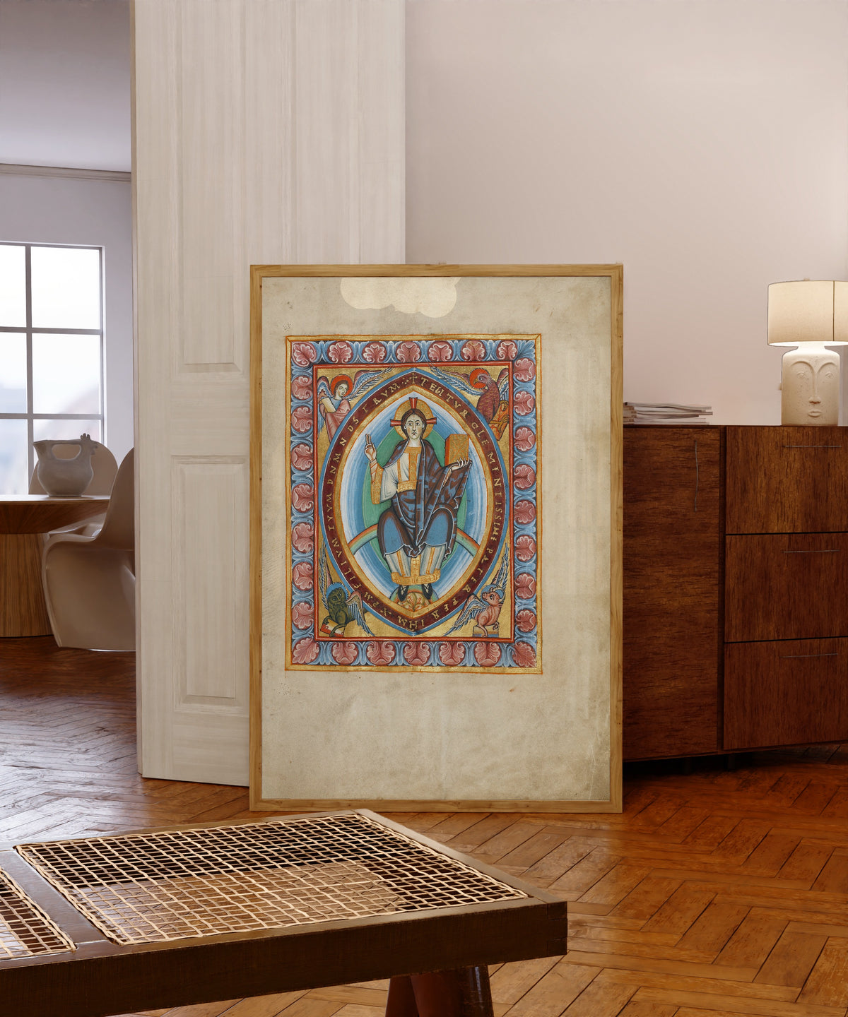 Framed art print of Christ in Majesty, in a light wood frame leaning in a warm room with a parquet floor
