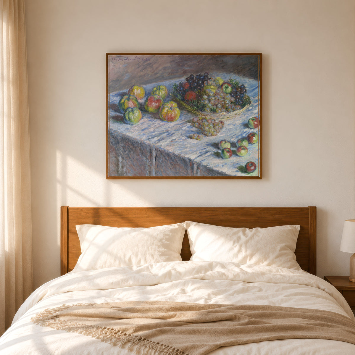 Framed art print of Apples and Grapes by Claude Monet, in a slim wood frame above a bed in a sunlit bedroom