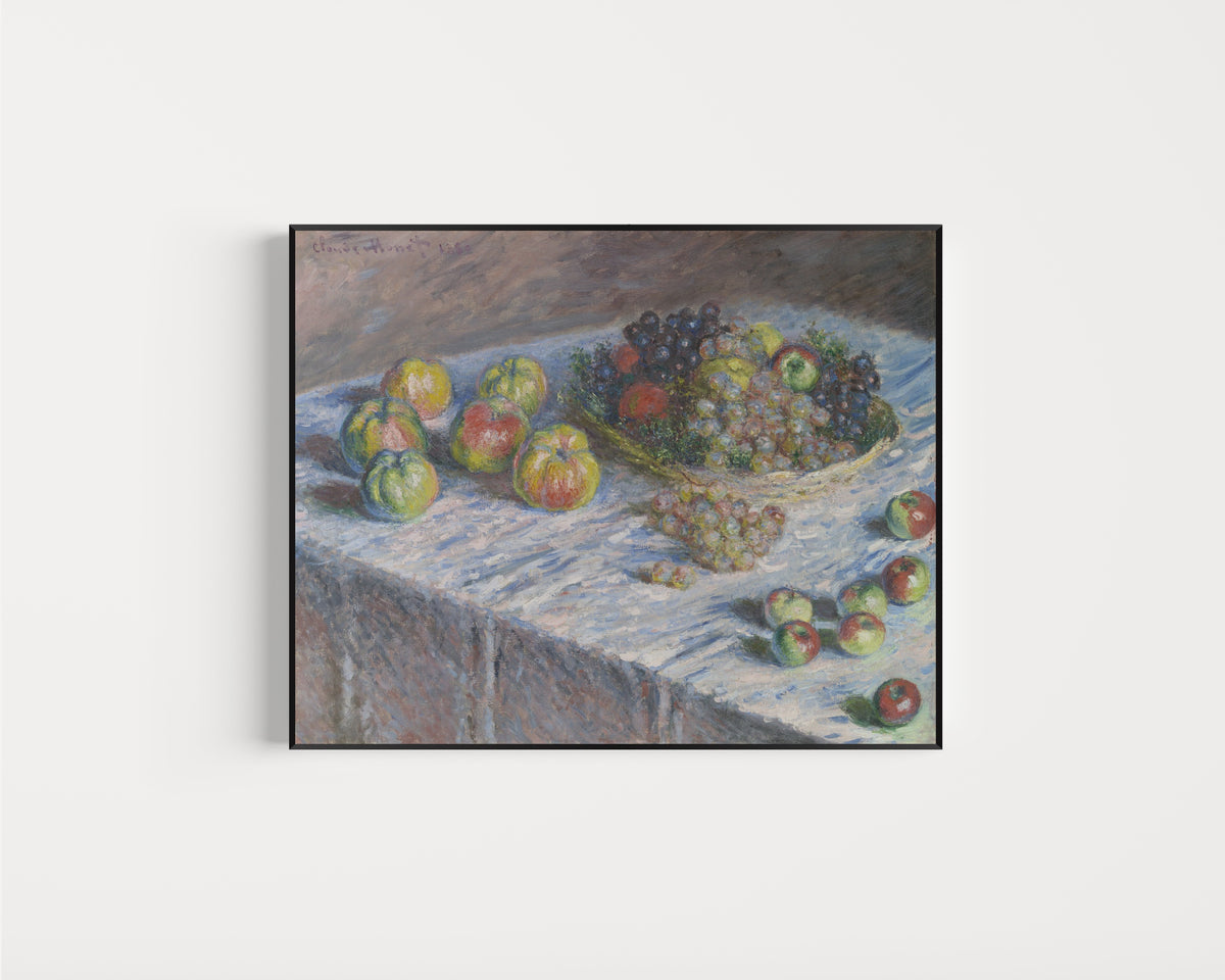 Framed art print of Apples and Grapes by Claude Monet, in a slim black frame on a plain white wall