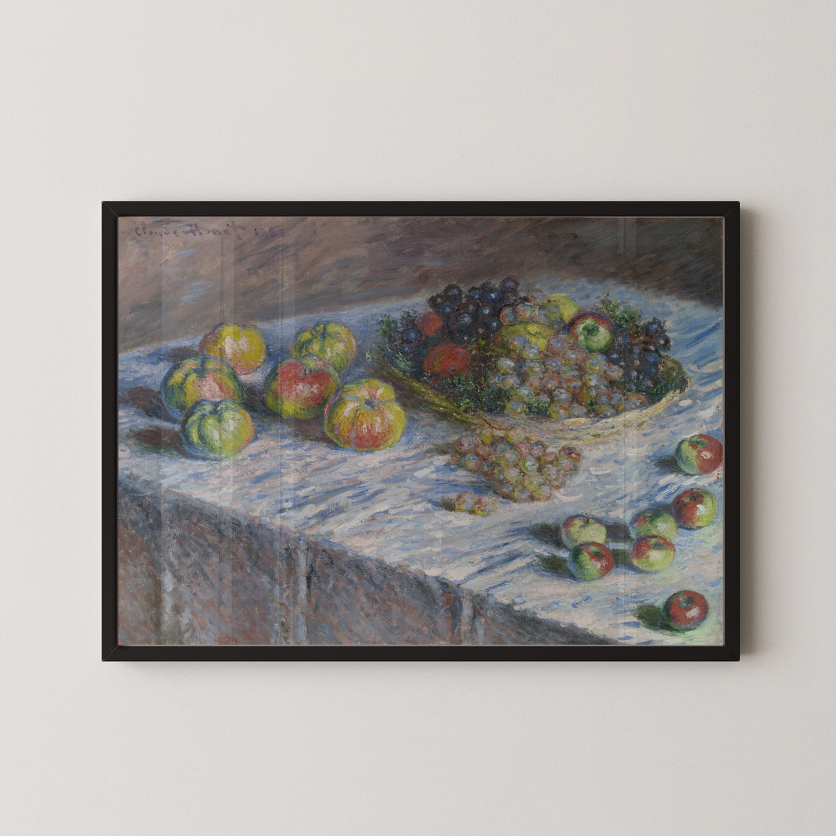 Apples and Grapes by Claude Monet — in a black frame on a pale wall