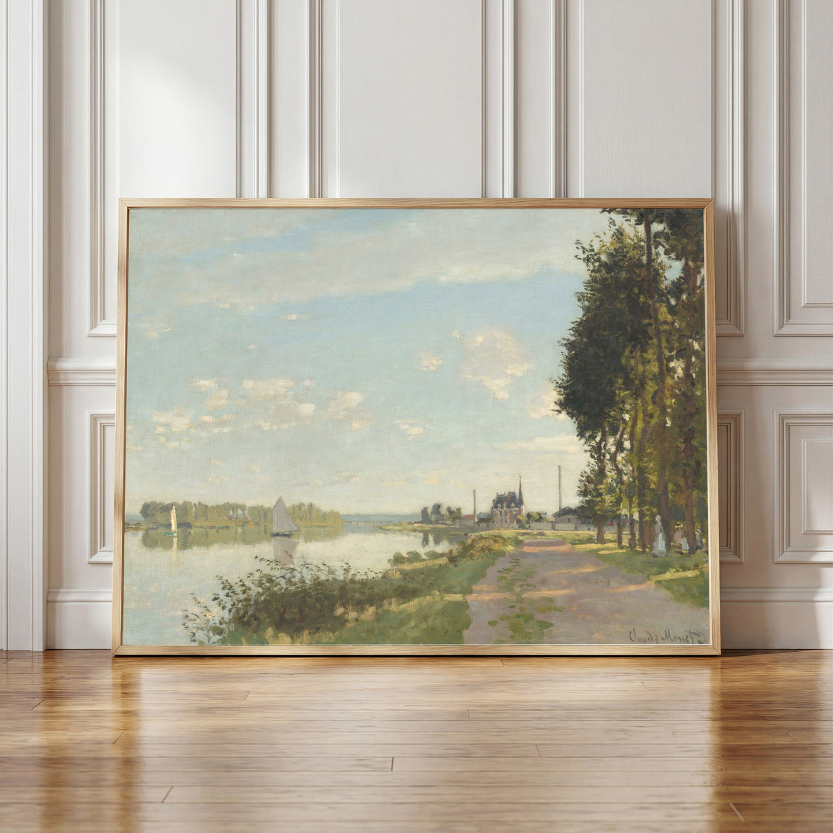 Framed art print of Argenteuil by Claude Monet, in a light wood frame leaning against a panelled white wall