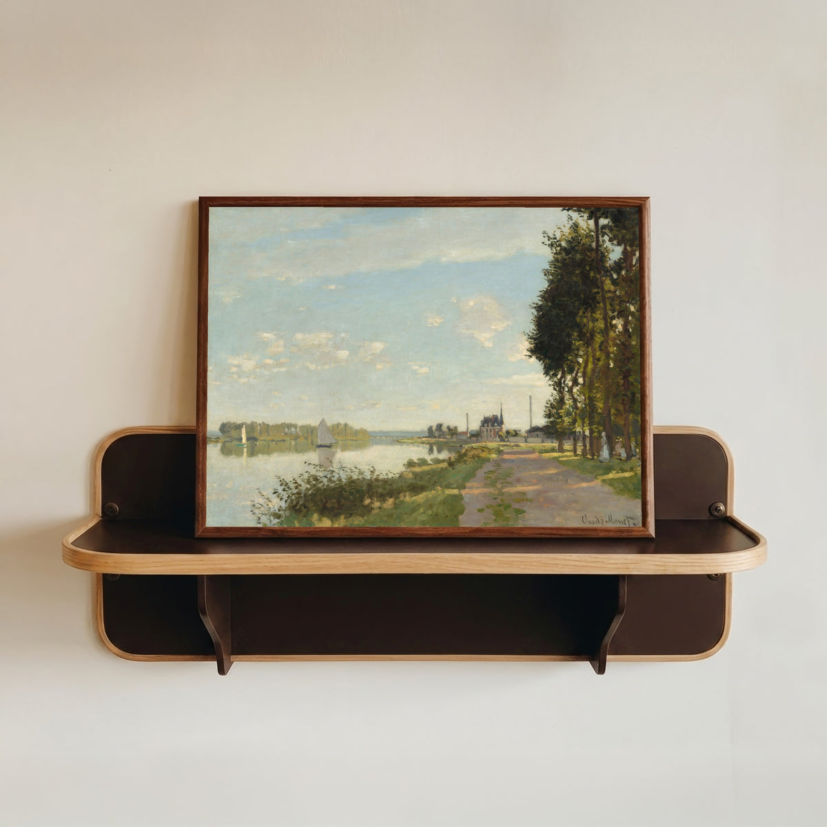 Framed art print of Argenteuil by Claude Monet, in a dark wood frame resting on a wall shelf