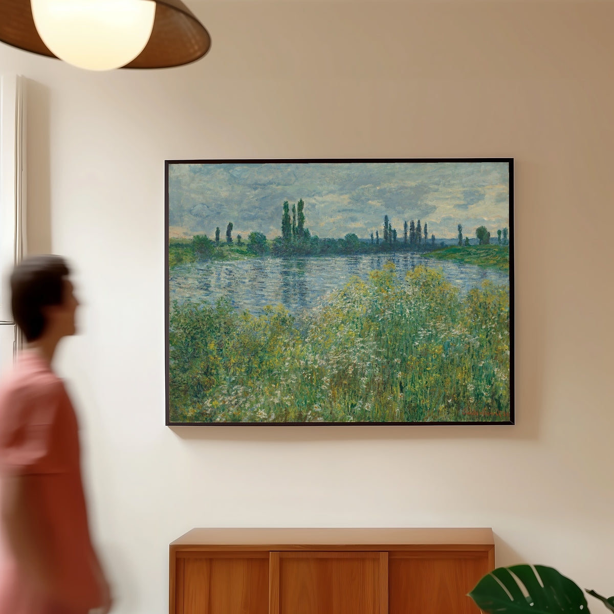 Framed art print of Banks of the Seine, Vetheuil by Claude Monet, in a slim black frame on a warm wall in a sunlit room