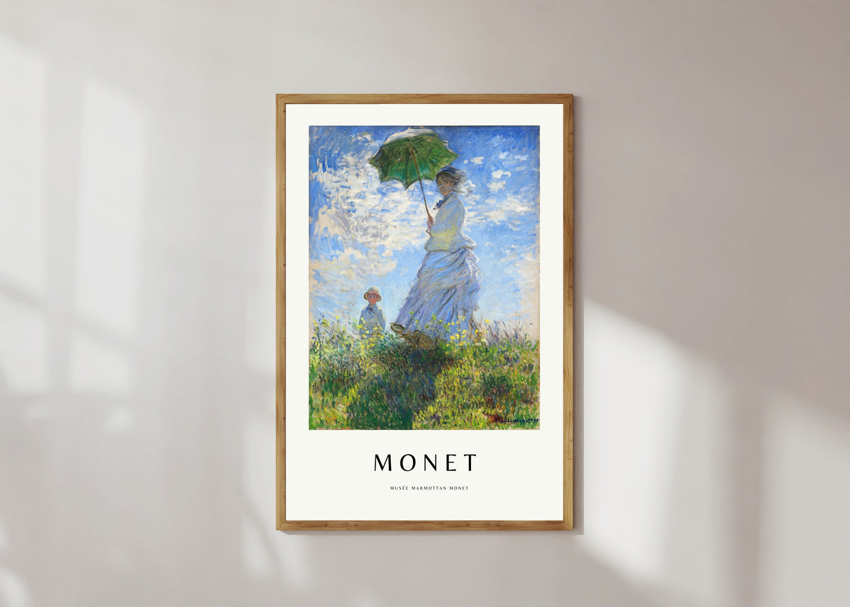 Framed art print of Madame Monet with a Parasol by Claude Monet, in a light wood frame on a sunlit white wall