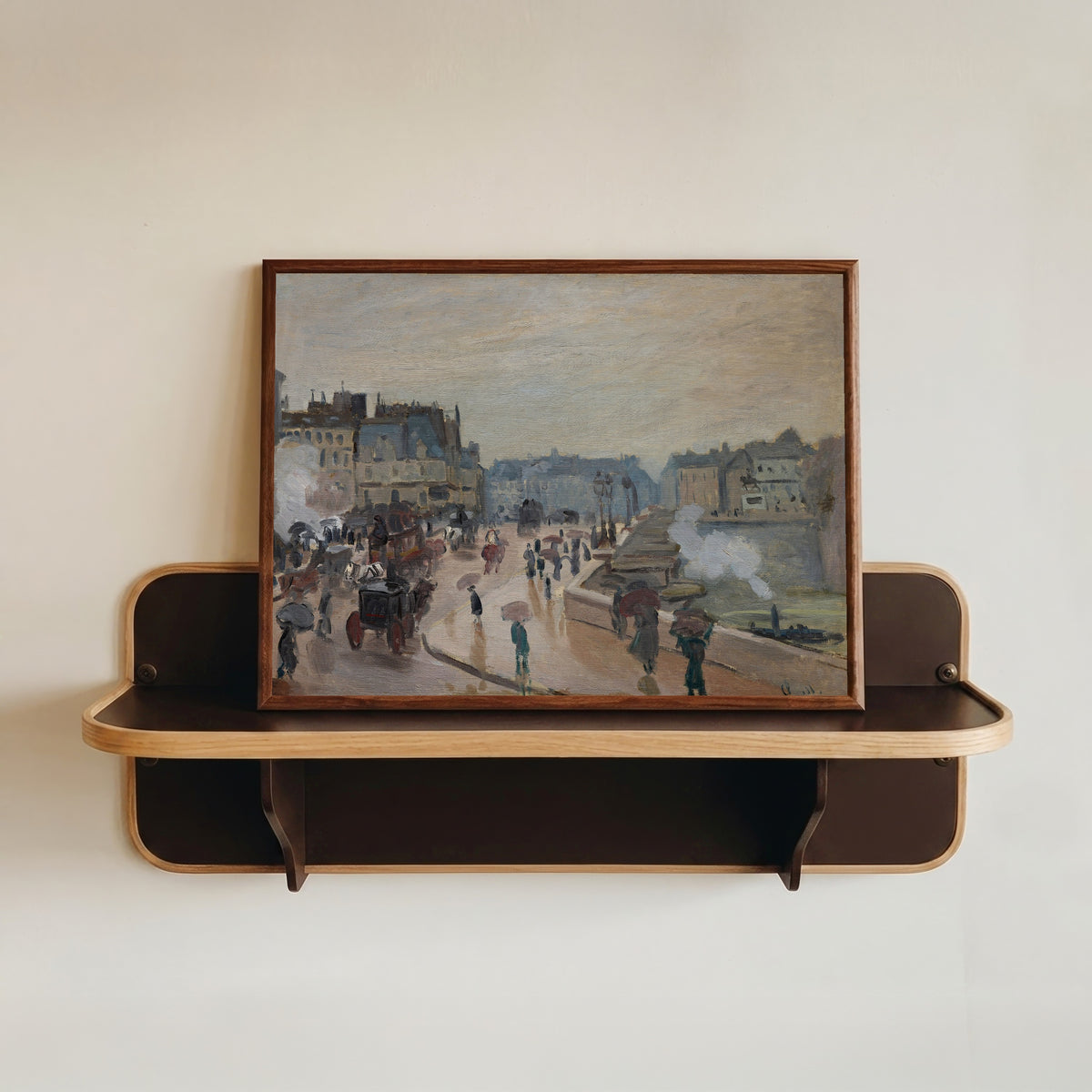 Framed art print of The Pont Neuf by Claude Monet, in a dark wood frame resting on a wall shelf