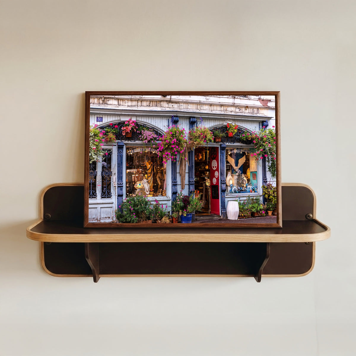 Framed art print of Colmar (Alsace) by Daniela Faust, in a dark wood frame resting on a wall shelf