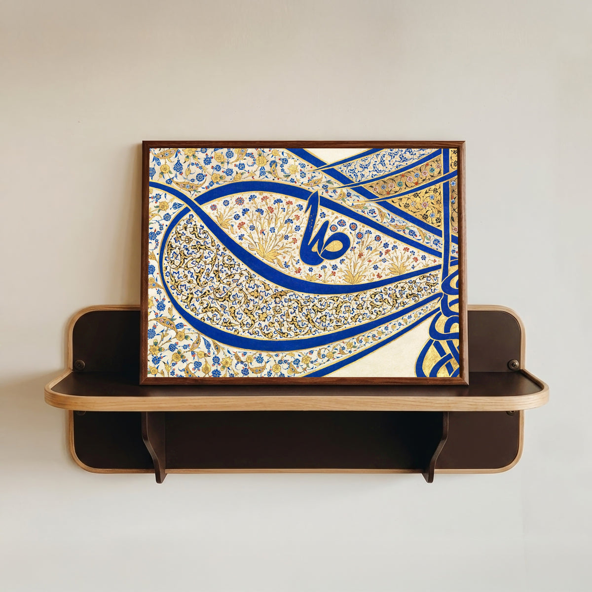 Framed art print of Tughra of Sultan Suleiman the Magnificent (16th Ct. Detail) by Sultan Suleiman, in a dark wood frame resting on a wall shelf