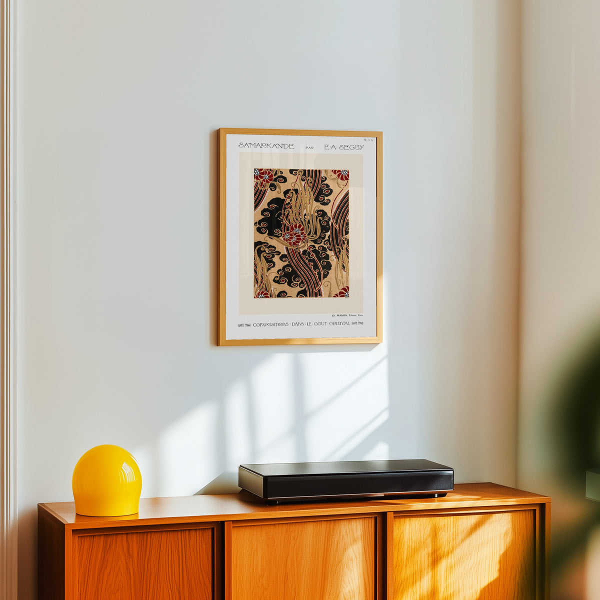 Framed art print of Samarkande, Plate 14 by E. A. Séguy, in a light wood frame on a white wall above an orange sideboard
