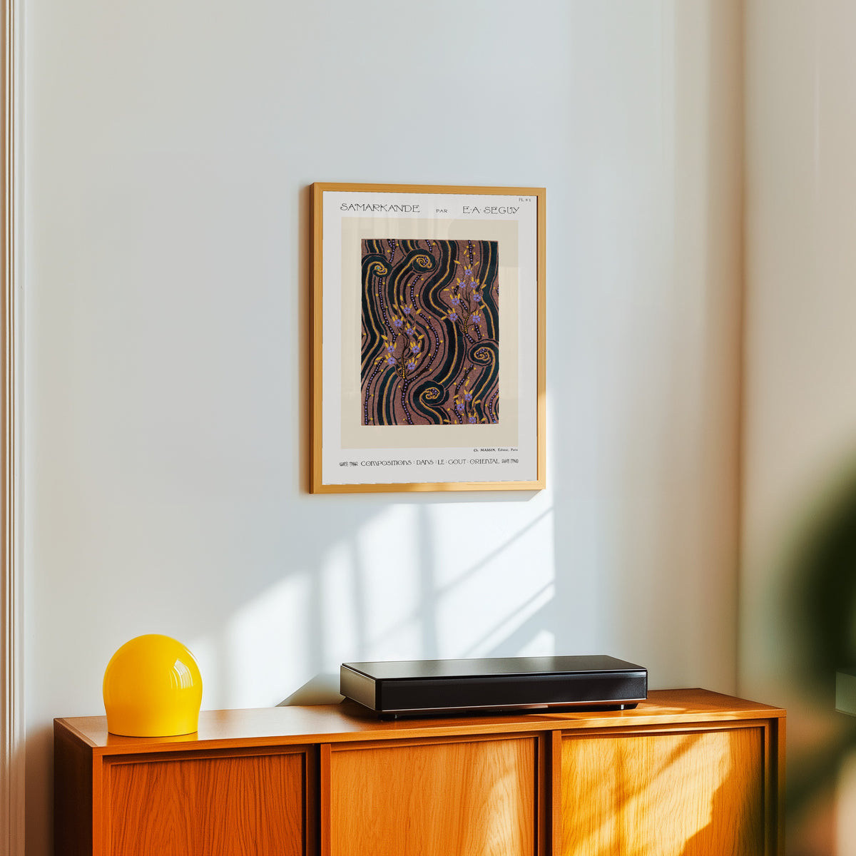 Framed art print of Samarkande, Plate 8 by E. A. Séguy, in a light wood frame on a white wall above an orange sideboard