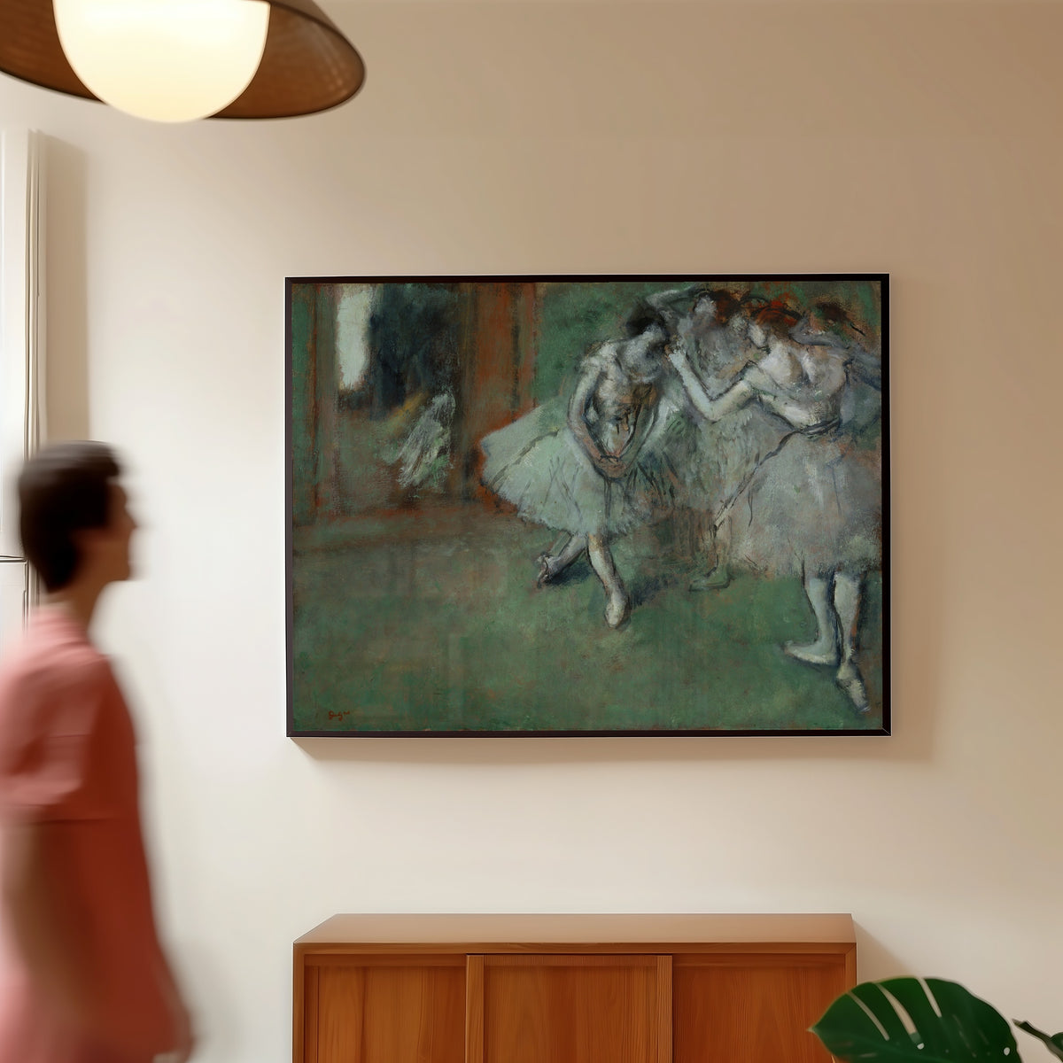 Framed art print of A Group of Dancers by Edgar Degas, in a slim black frame on a warm wall in a sunlit room