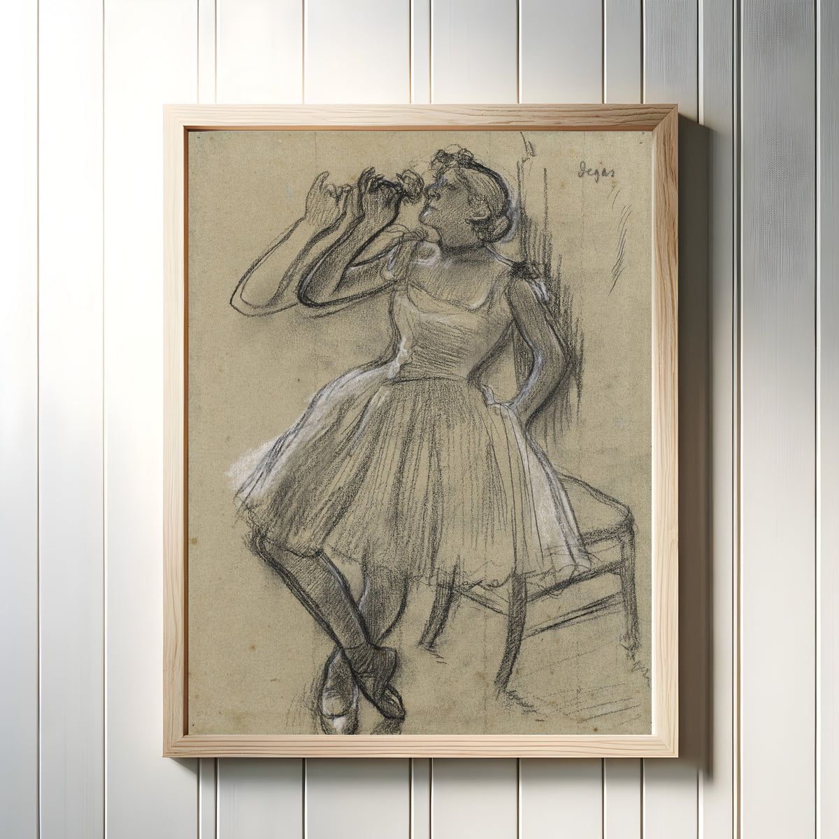 Framed art print of Danseuse à la rose by Edgar Degas, in a light wood frame on a white panelled wall