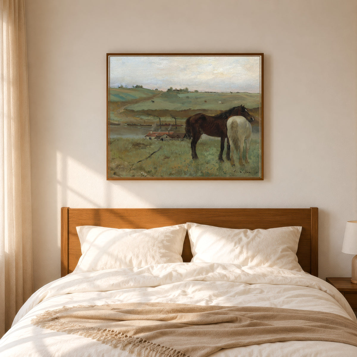 Framed art print of Horses in a Meadow by Edgar Degas, in a slim wood frame above a bed in a sunlit bedroom