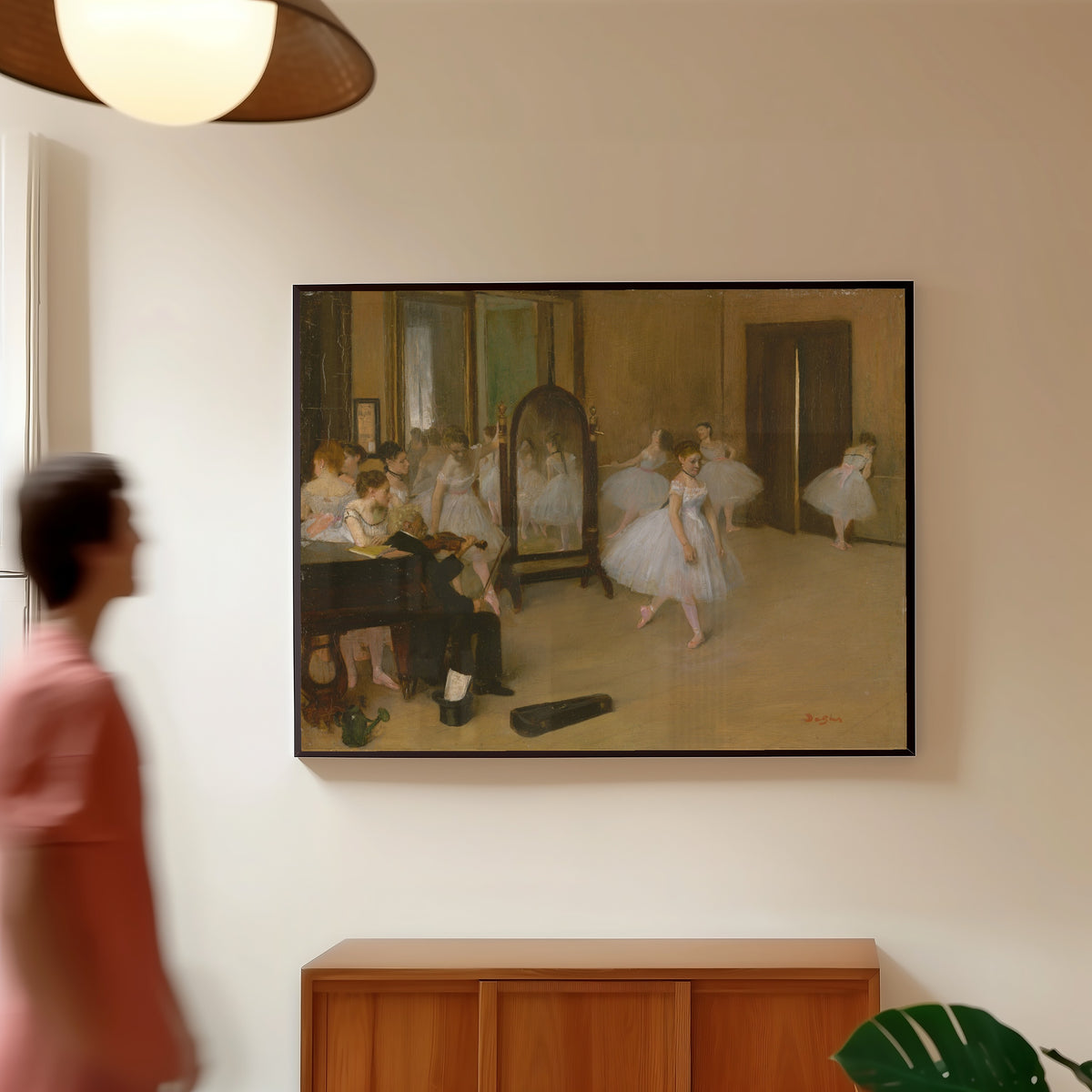 Framed art print of The Dancing Class by Edgar Degas, in a slim black frame on a warm wall in a sunlit room