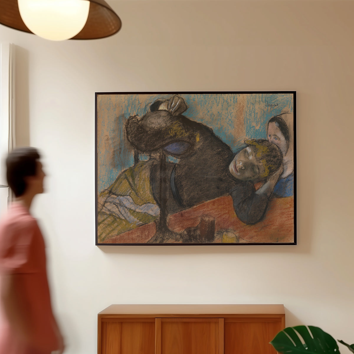 Framed art print of The Milliner by Edgar Degas, in a slim black frame on a warm wall in a sunlit room