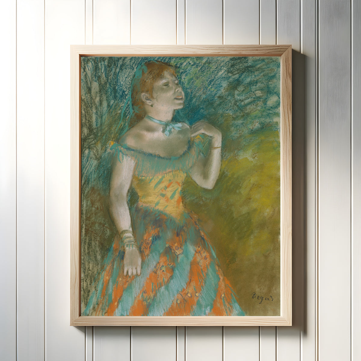 Framed art print of The Singer in Green by Edgar Degas, in a light wood frame on a white panelled wall